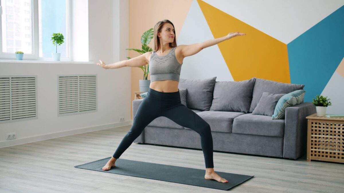 Woman in activewear doing yoga in living room. Bright, modern interior.