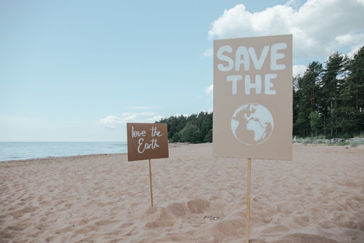 Signs advocating environmental protection on a serene sandy beach.